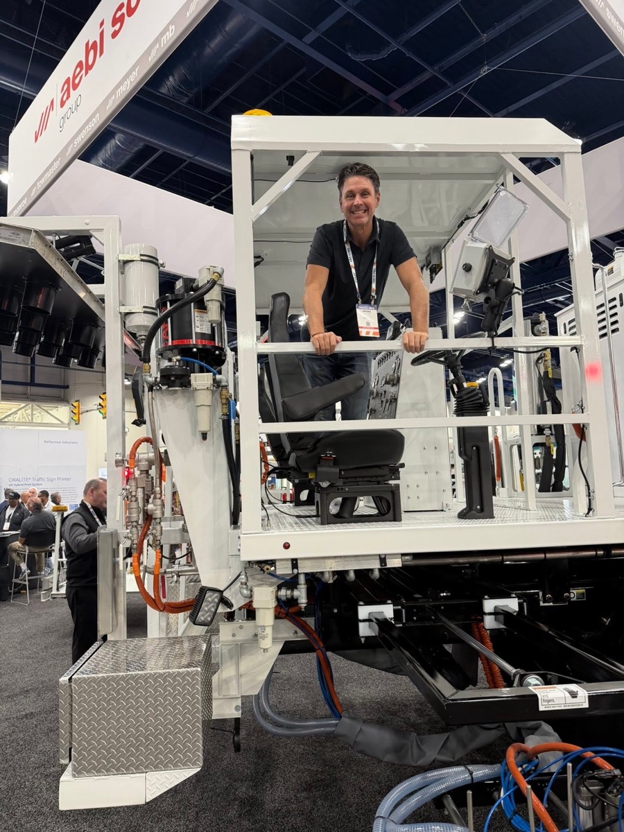 Premier Striping team member on the operator platform of a line-striping truck