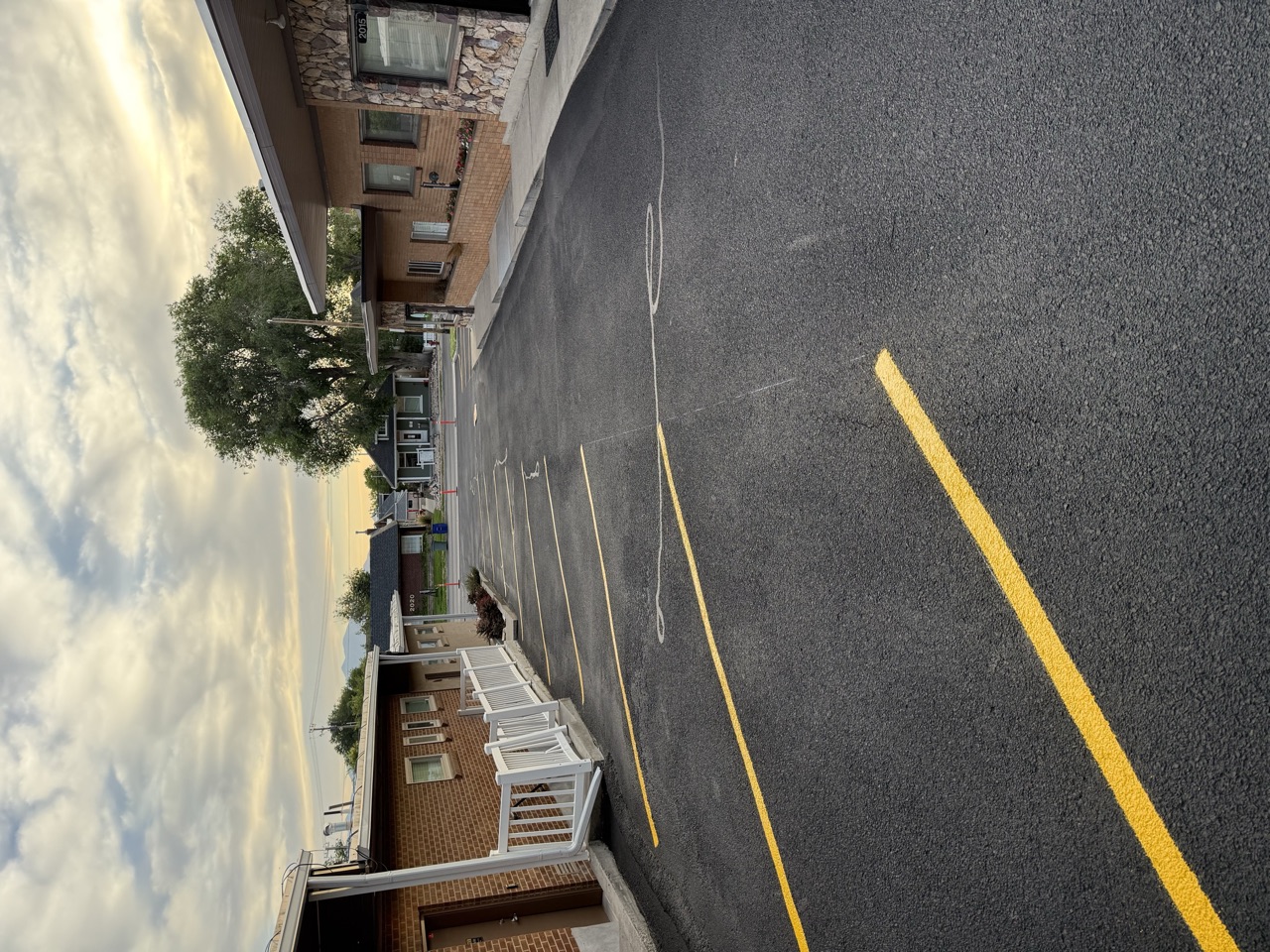 Yellow parking stall lines between a row of small businesses