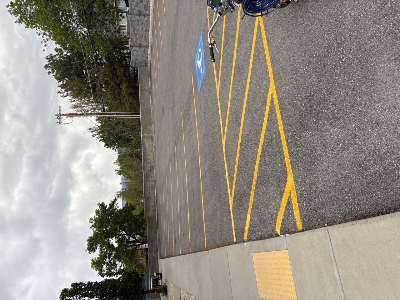 Fresh yellow access aisle beside a curb and striping machine