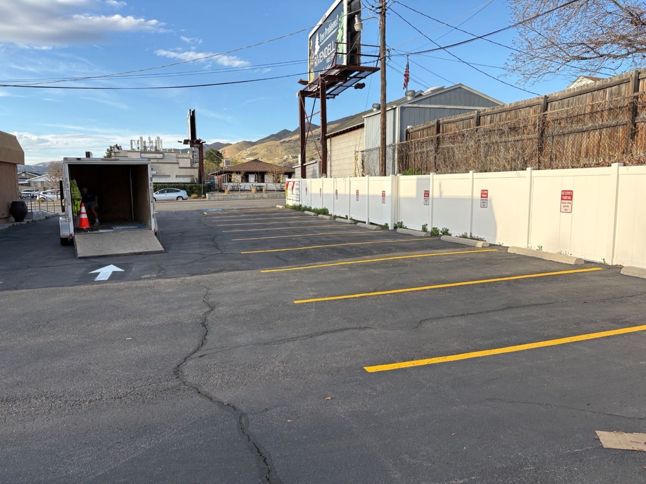 Yellow parking stalls and a white directional arrow beside a work trailer