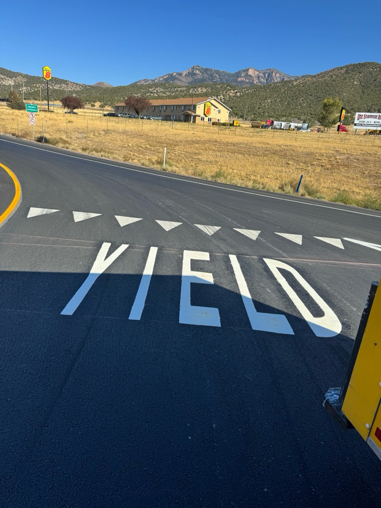 Large white YIELD marking with yield triangles on a roadway